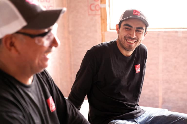 Two Owens Corning insulation installation technicians smiling during a conversation