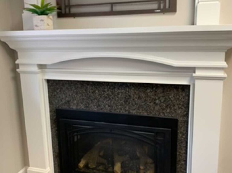 A mentle fireplace with granite detailing is installed in a living space