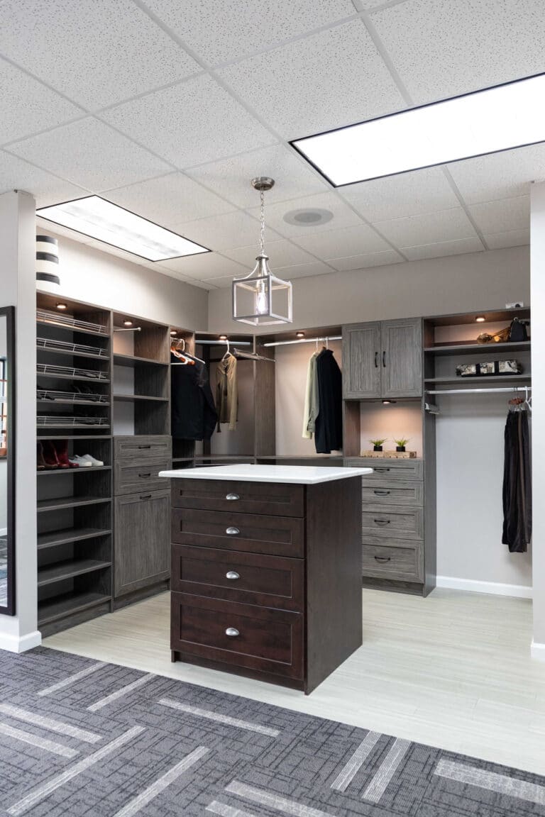 A custom closet setup with racks for shoes, suits, clothing and custom drawer solutions