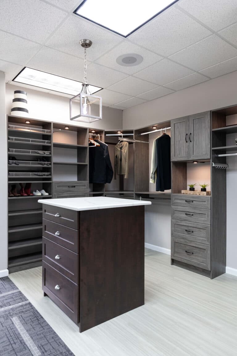 A custom closet setup with racks for shoes, suits, clothing and custom drawer solutions