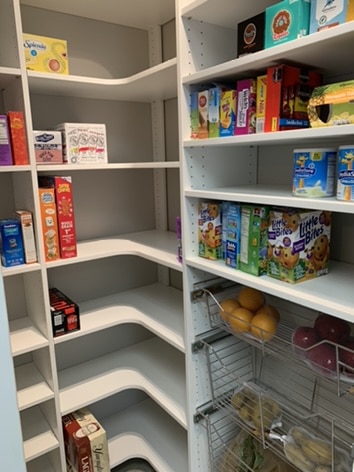 A custom pantry build with groceries and dry goods lining the white shelves