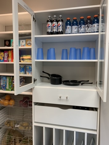 A custom pantry build with groceries and dry goods lining the white shelves