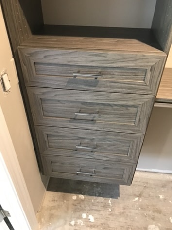 Drawers with silver pulls inside a custom closet
