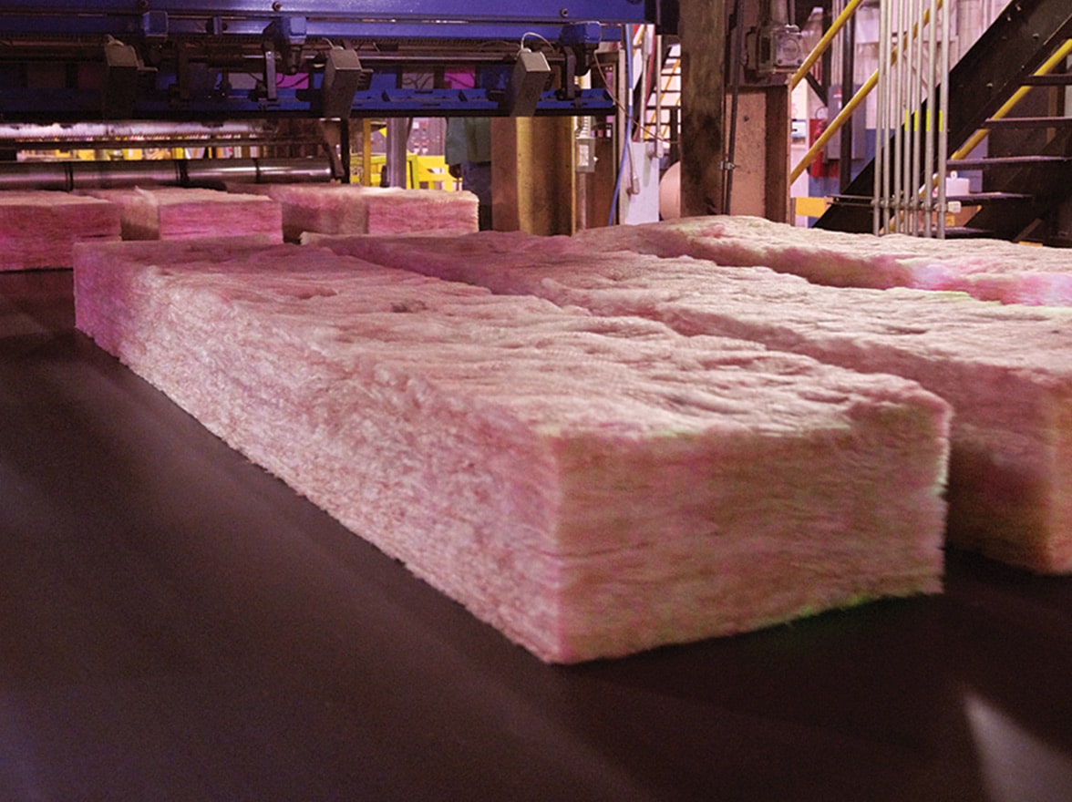 Brand new sections of batt insulation rolling through a production facility