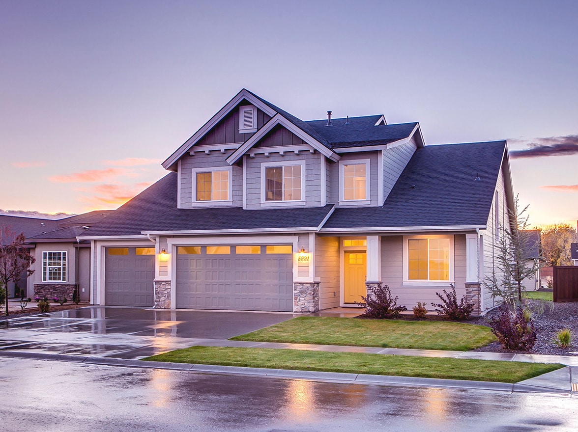 A modern home with interior lights on at dusk