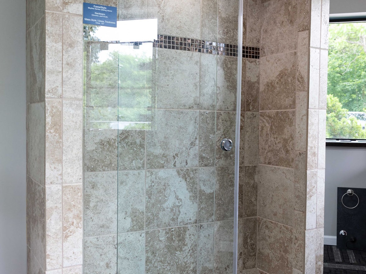 A brass frameless shower door in the MIG Building Systems show room