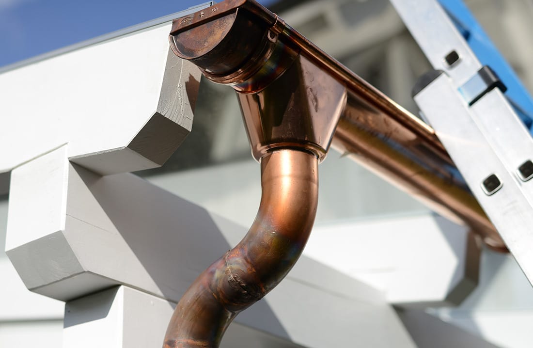 A copper gutter system on the side of a home