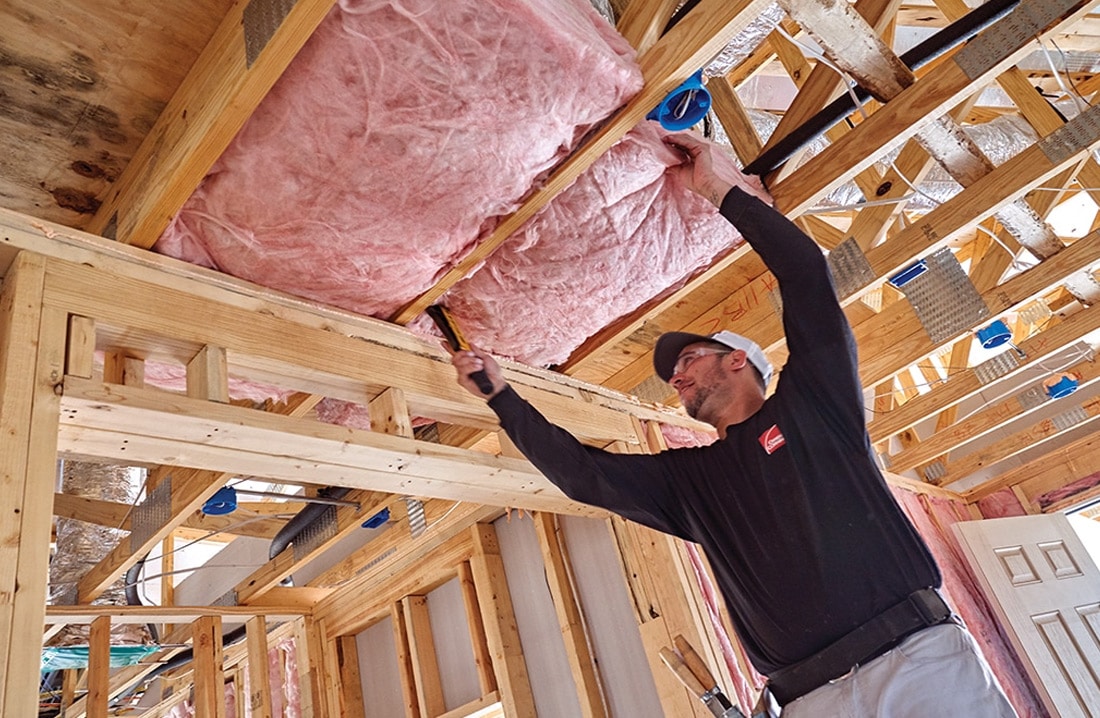 An installer putting up new radiant barrier insulation in a home